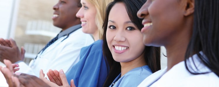 Health professionals smiling with woman looking at camera