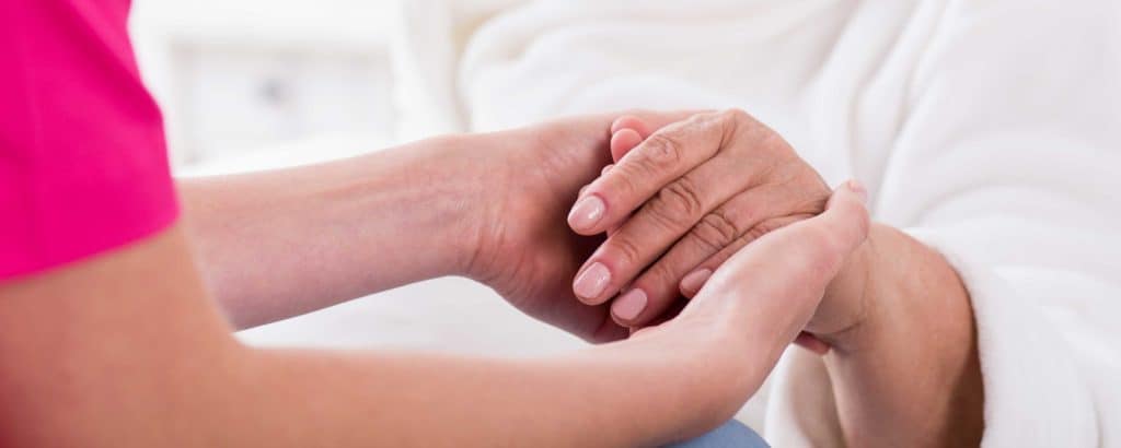 Nurse holding hands of patient