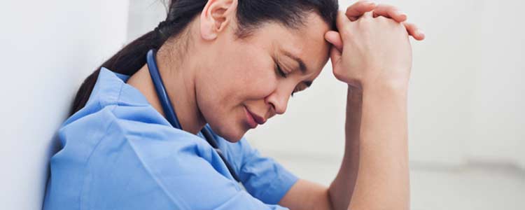 Nurse looking stressed with eyes closed