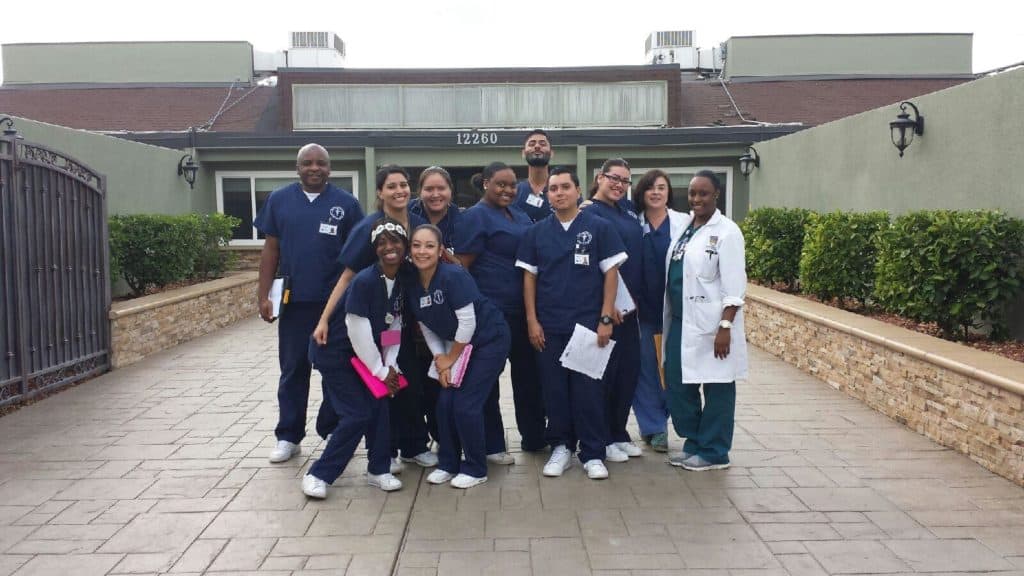 CDI Students and Instructor Smiling in front of clinic